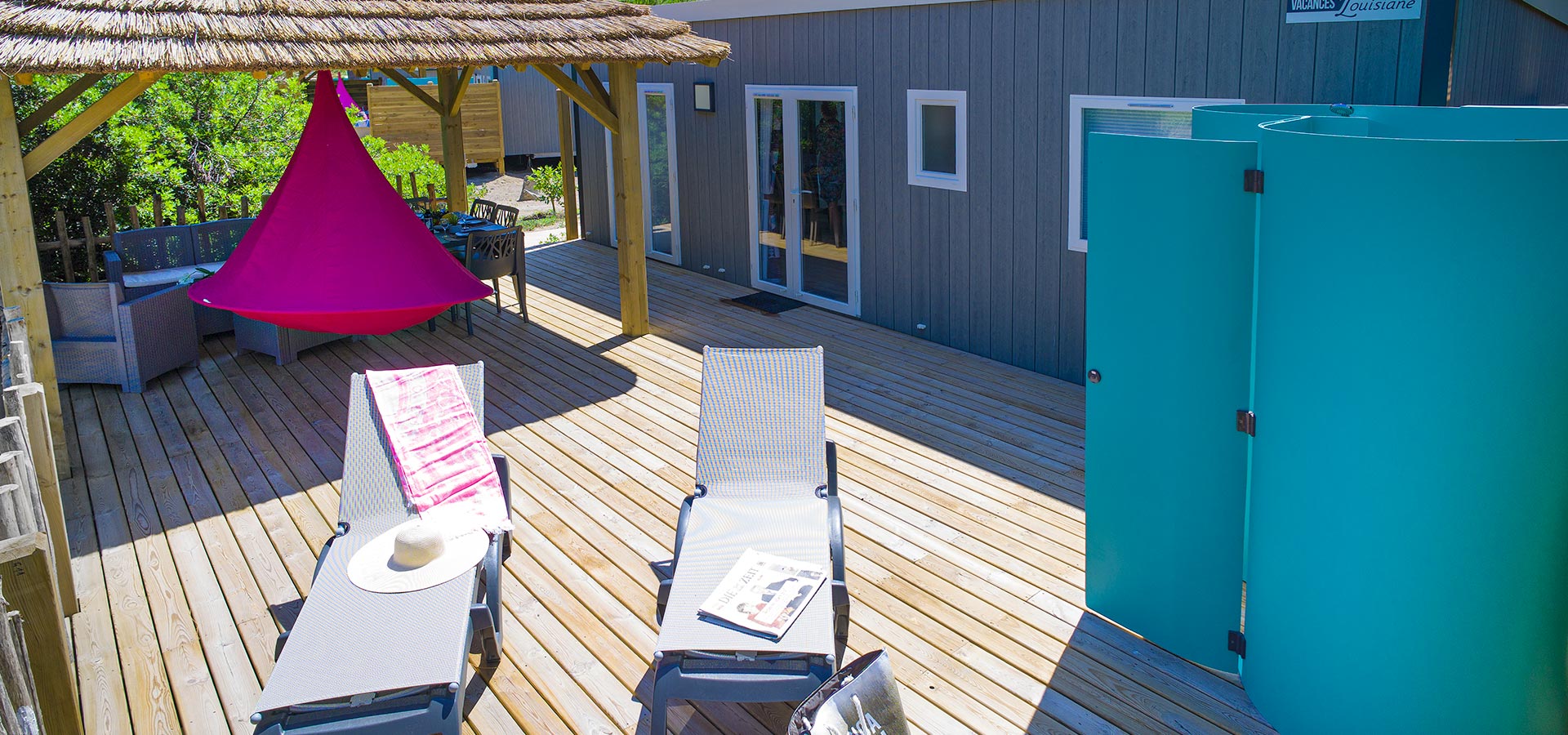 Camping san damiano bungalow luxe Capraia vue mer grande terrasse transat salon jardin douche exterieure paillote